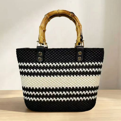 Completed easy crochet tote bag in classic black with cream stripes, bamboo handle, and black PU leather base attachments.